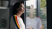 Herbstblues: Eine Frau schaut durchs Fenster in den Regen.