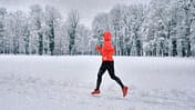 Snow Running: Eine Läuferin läuft durch einen tief verschneiten Park