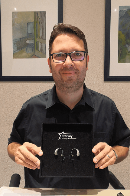 Hörgeräteakustiker Christof Dehn mit dem Hörgerät Livio Al 2400 von Starkey.